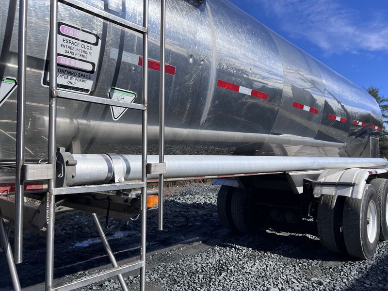 Close view of a stainless ladder and the confined space warning sign on the tank.
